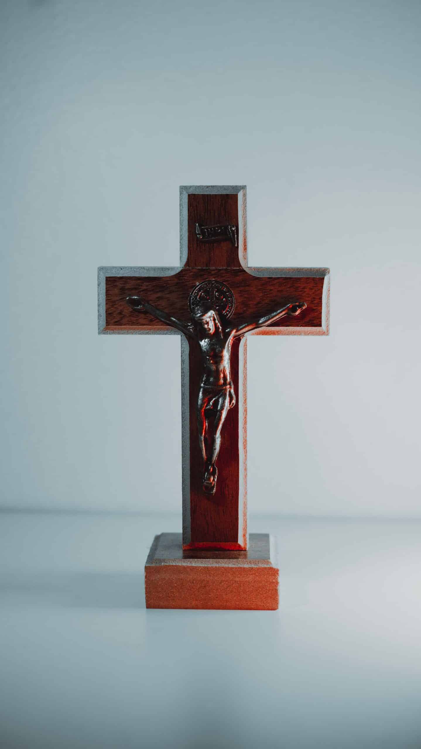 A wooden crucifix depicting Jesus Christ against a plain white background.