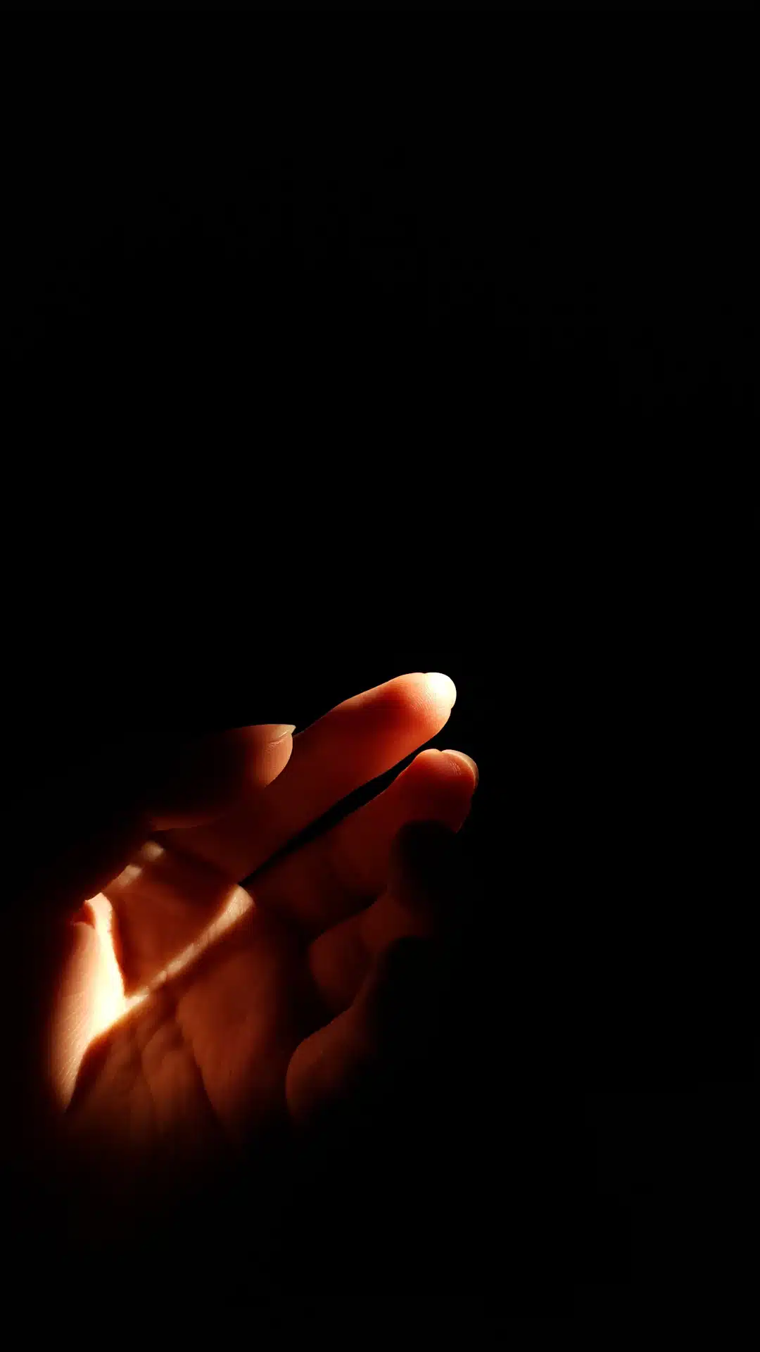 a hand holding a cell phone in the dark