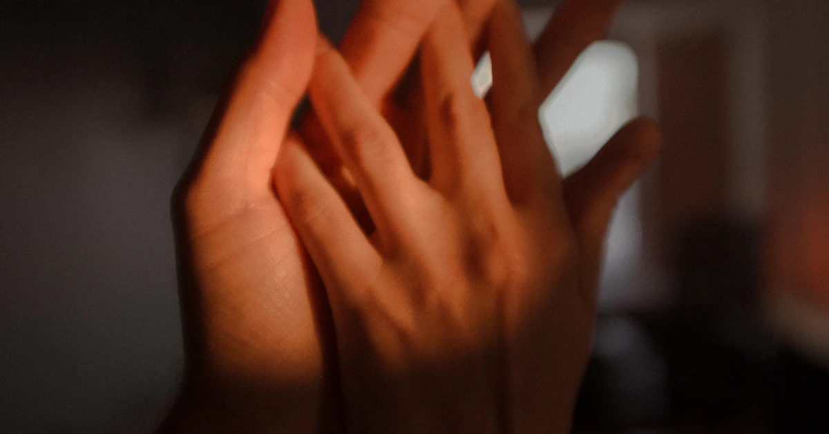 persons left hand on dark room