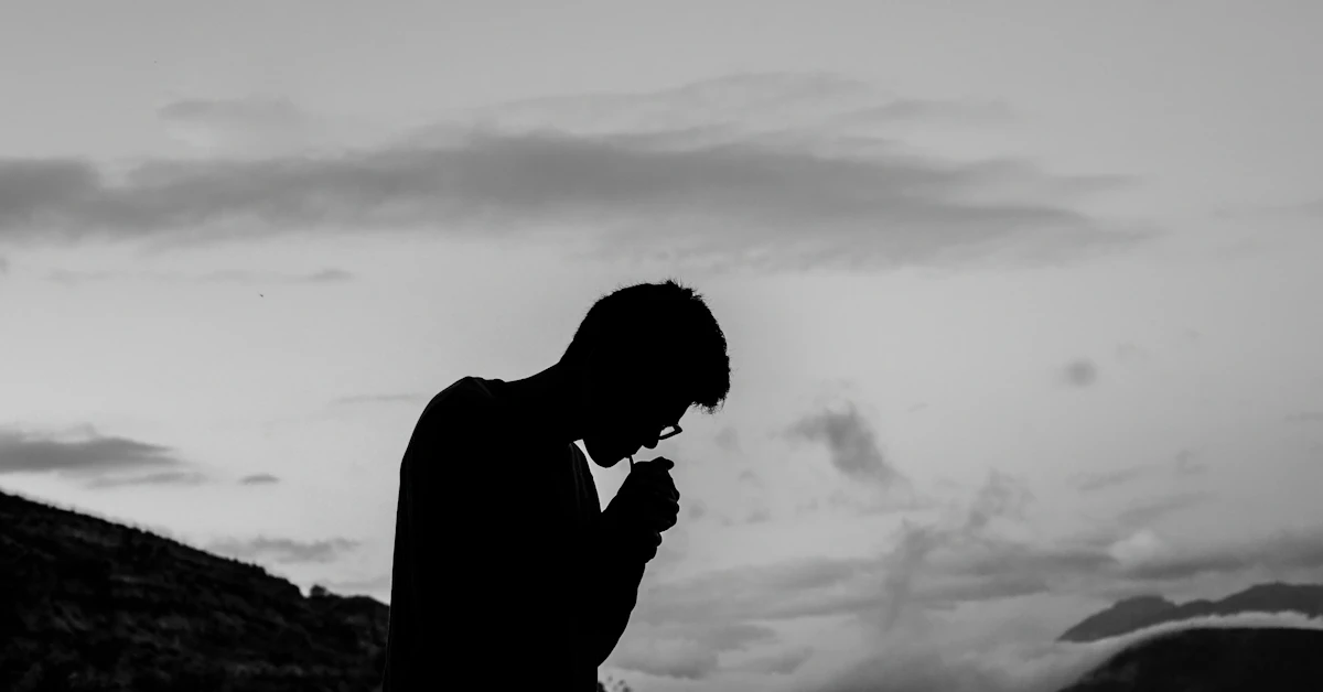 silhouette photo of man smoking outdoors