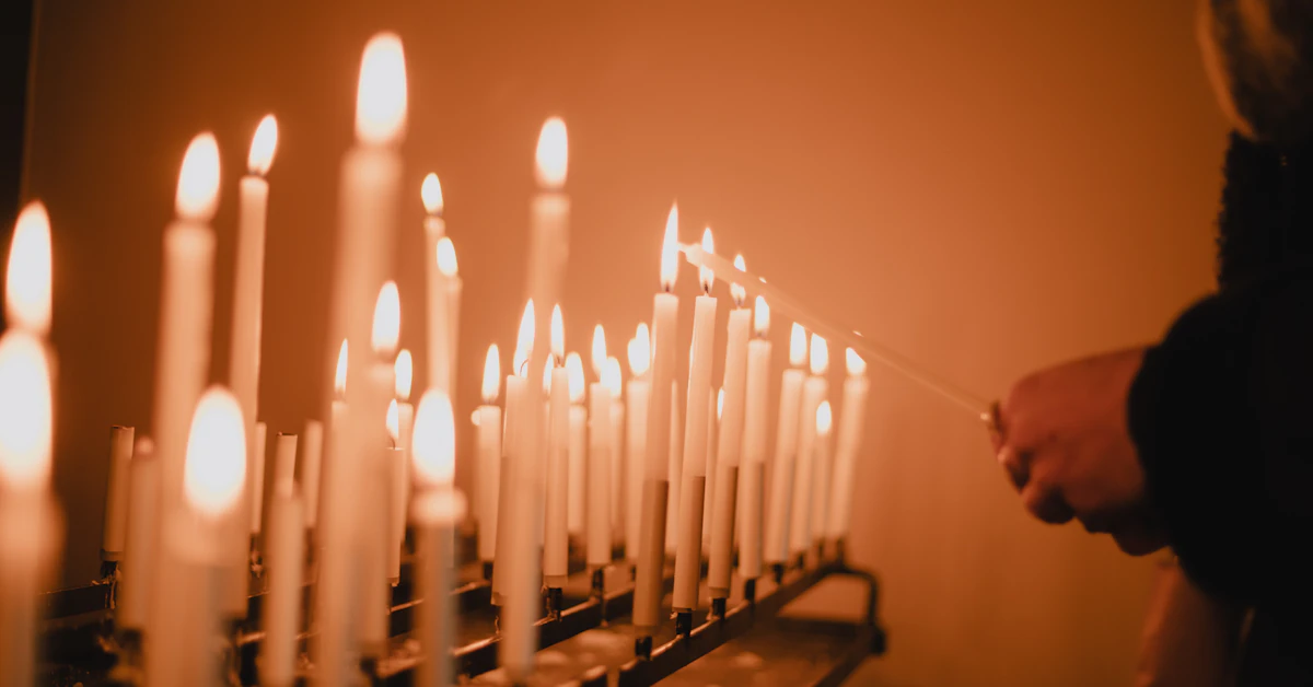 man standing near lighted candles